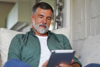 Man on the couch looking at tablet