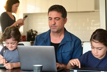 Man working from home next to children