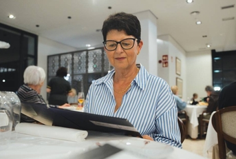 senior woman is sitting at a restaurant table
