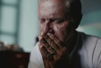 Portrait of older man with face in hands