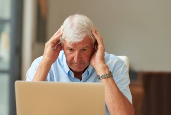 Stressed senior man on laptop