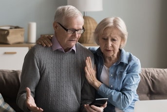 Concerned retired couple on couch 