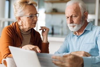 Senior couple reviewing paperwork in kitchen