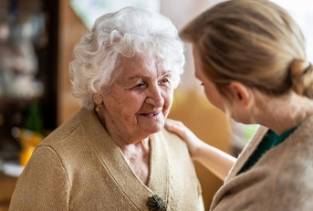 Health visitor talking to a senior woman during home visit
