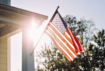 American flag on home with sun in background