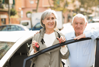 Couple in their 60s with car