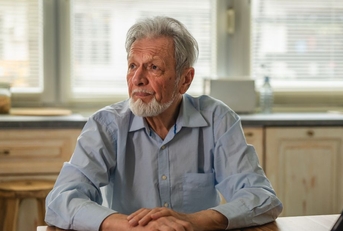 Contemplating older man in kitchen 