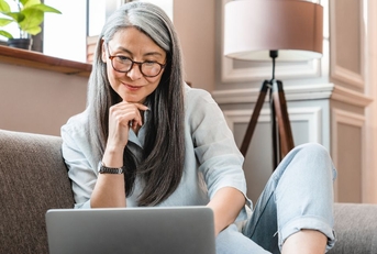 Older woman on couch with laptop
