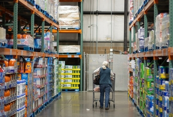 Older woman shopping down a Costco aisle