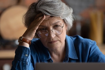 Stressed older woman on laptop