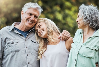 Senior couple embracing adult daughter