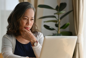 Mature woman on laptop in dining room