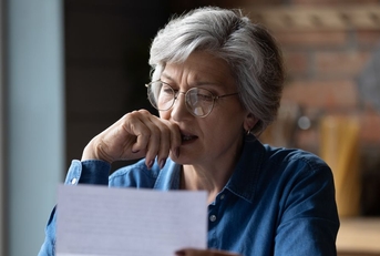 Concerned older woman reviewing letter