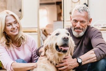 Couple in their 60s petting a dog