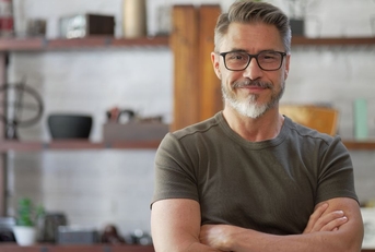 Smiling man in his 40s with crossed arms