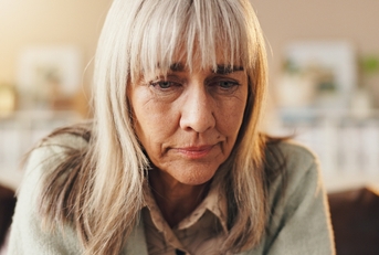 Older woman looking down sad