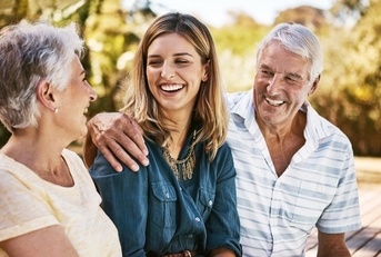Senior parents smiling with adult daughter