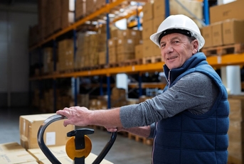 Older male warehouse worker smiling