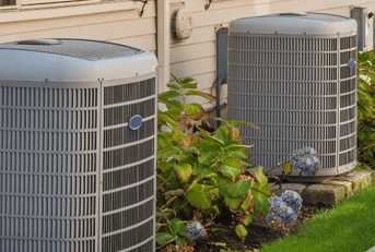 A row of new air conditioning units behind townhomes