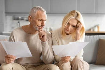 Mature couple on couch reviewing papers
