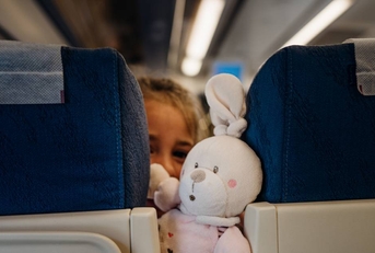 Child peeking between seats on airplane