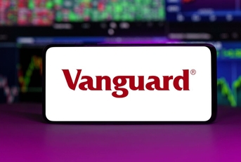 Vanguard displayed on mobile phone with stock market chart background