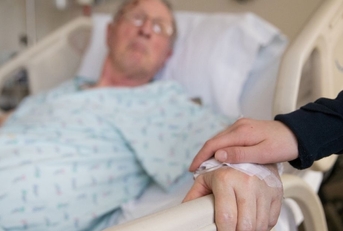holding hands with elderly patient at hospital
