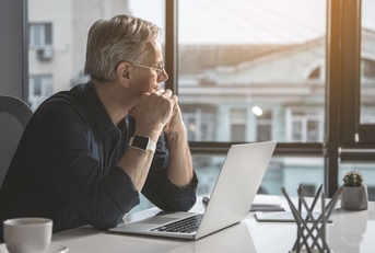 Pensive looking mature man with laptop
