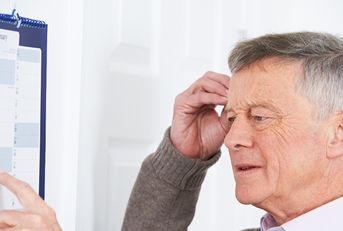 Older man looking at calendar confused