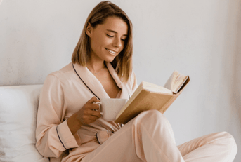 Woman drinking coffee in luxurious bedroom