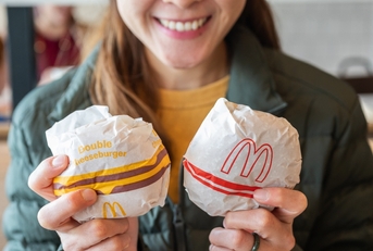 Woman smiling and holding two burgers from McDonalds