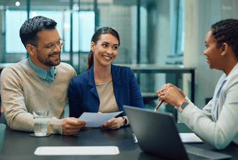 Young couple sitting with financial advisor at bank