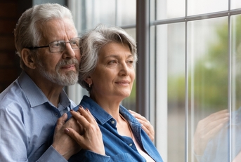 Senior couple looking through the window