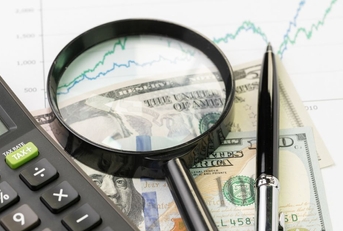 Cash with a yield graph, magnifying glass, calculator, and pen