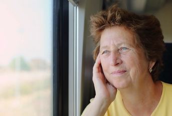Woman in her late 70s looking through the window