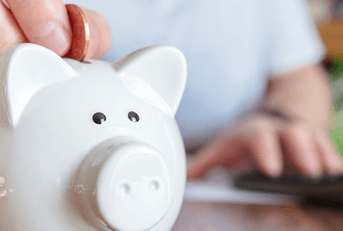Man putting coins in piggy bank