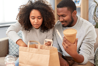 Couple eating takeout food at home