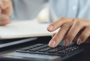 Woman reviewing finances with calculator