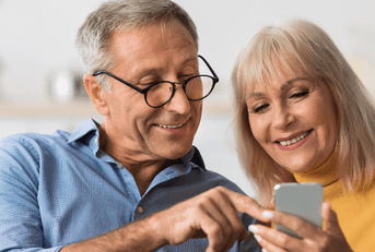 Older couple checking retirement accounts on phone