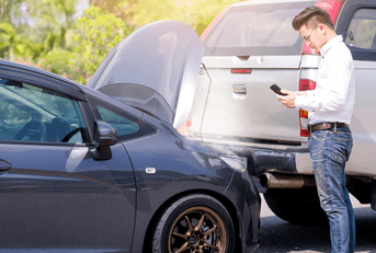 Man examining damage after car accident