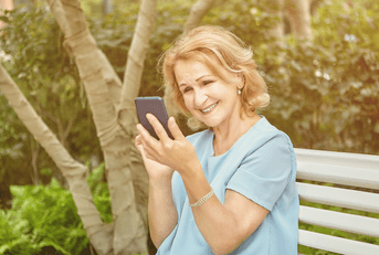Senior retiree woman looking at investments on phone