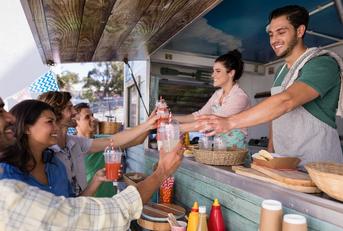 waitress and waiter giving juice to customer at counter