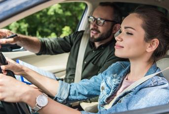 Student driving a car with teacher