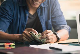 hands of young businessman counting money