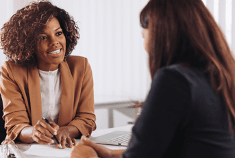 two women talking at bank