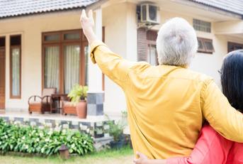 elderly man pointing to a house