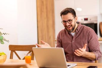 Smiling man working from home on a laptop