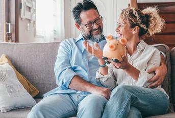 caucasian couple holding piggy bank