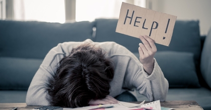 stressed woman holding up help sign