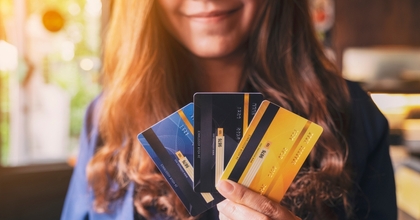Smiling woman holding three credit cards